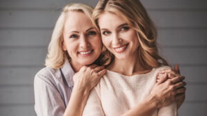 A mother and daughter smiling with straight, white teeth.